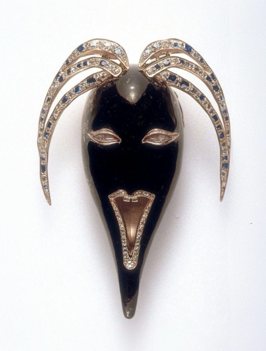 The Scream Brooch by Nilofar — a carved dark mask face with gold detailing and diamond-and-sapphire brows, a one-of-a-kind fine jewelry piece